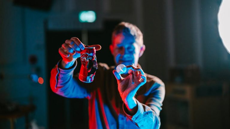 Pierre Wets, flou, tenant dans ses mains une cannette de soda et une balle de ping-pong cassées © EPFL 2024 / Adrien Buttier